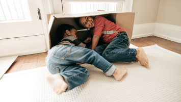 Two lively boys playing inside their home with a cardboard box Wilxcox Electric DC
