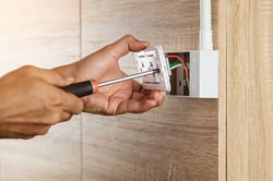 An Electrician Using A Screwdriver to Install an Electric Outlet