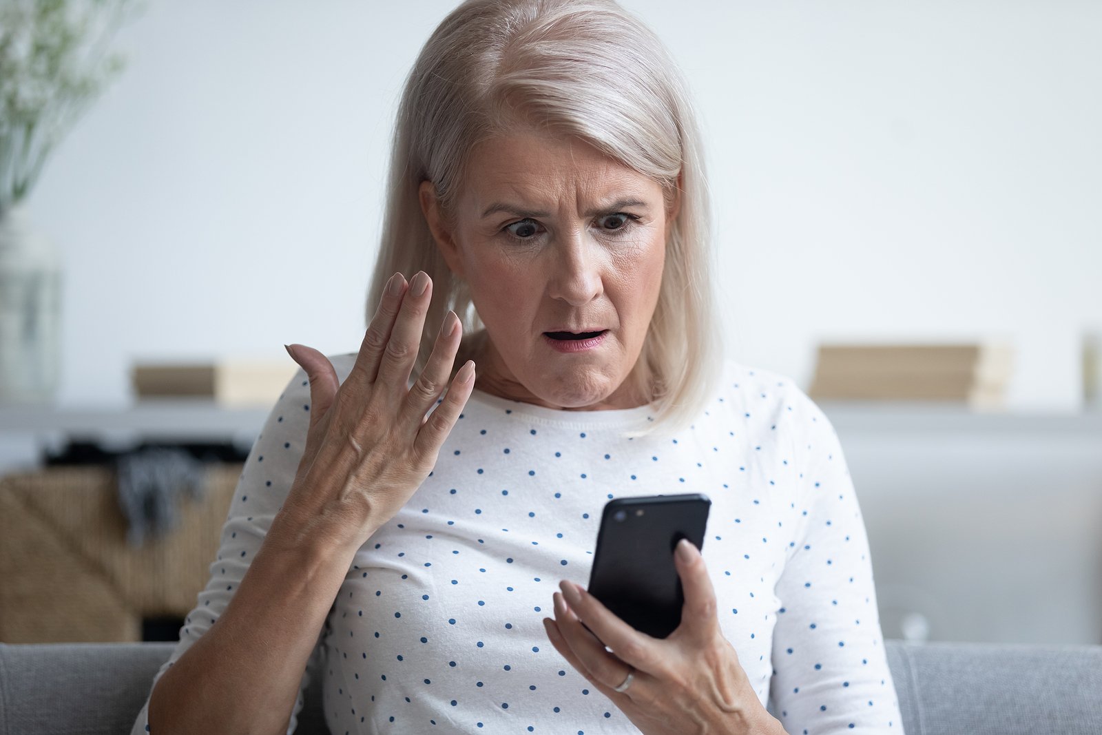 bigstock-Mad-Elderly-Woman-Holding-Smar-336837388