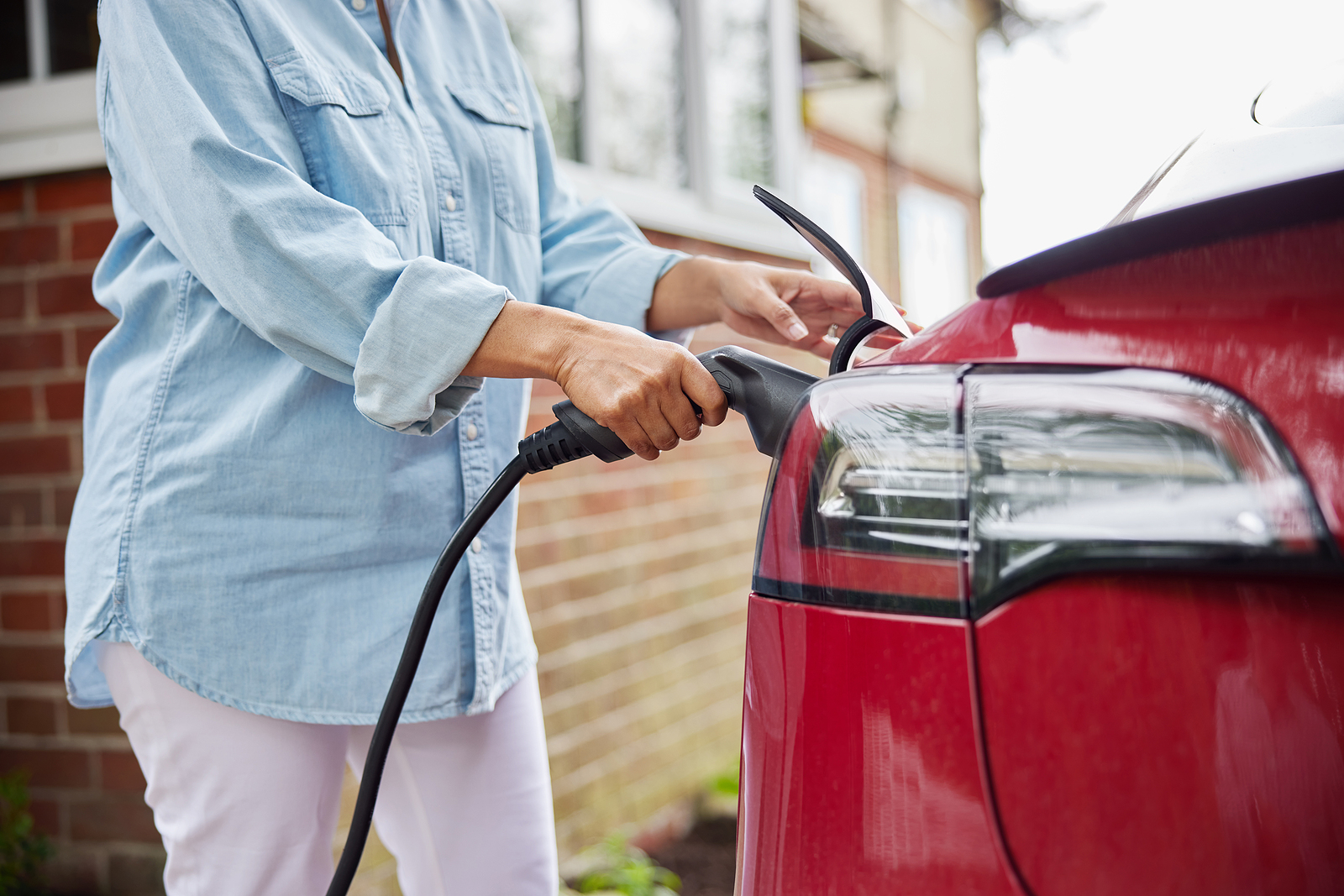 Woman-Attaching-EV-charger-Wilcox-Electric-DC