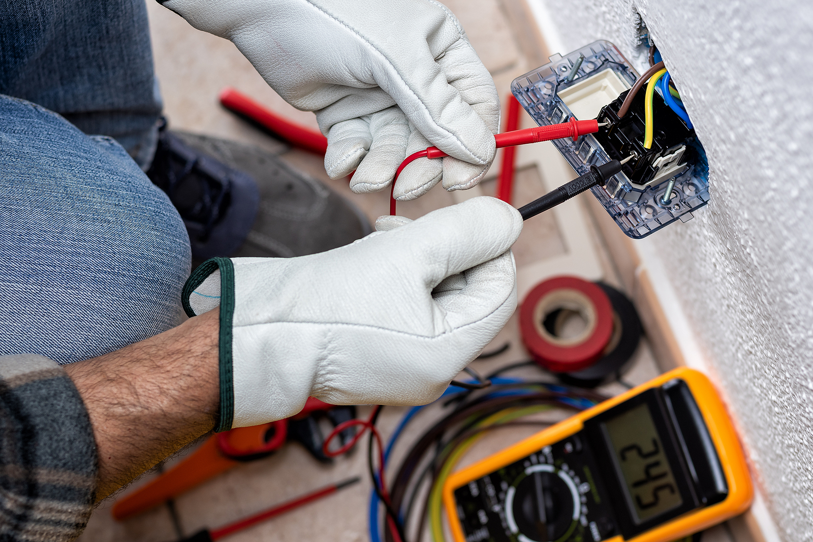 Close of the hands of an electrician using specialized meter to check an electric recepticle Wilcox Electric DC