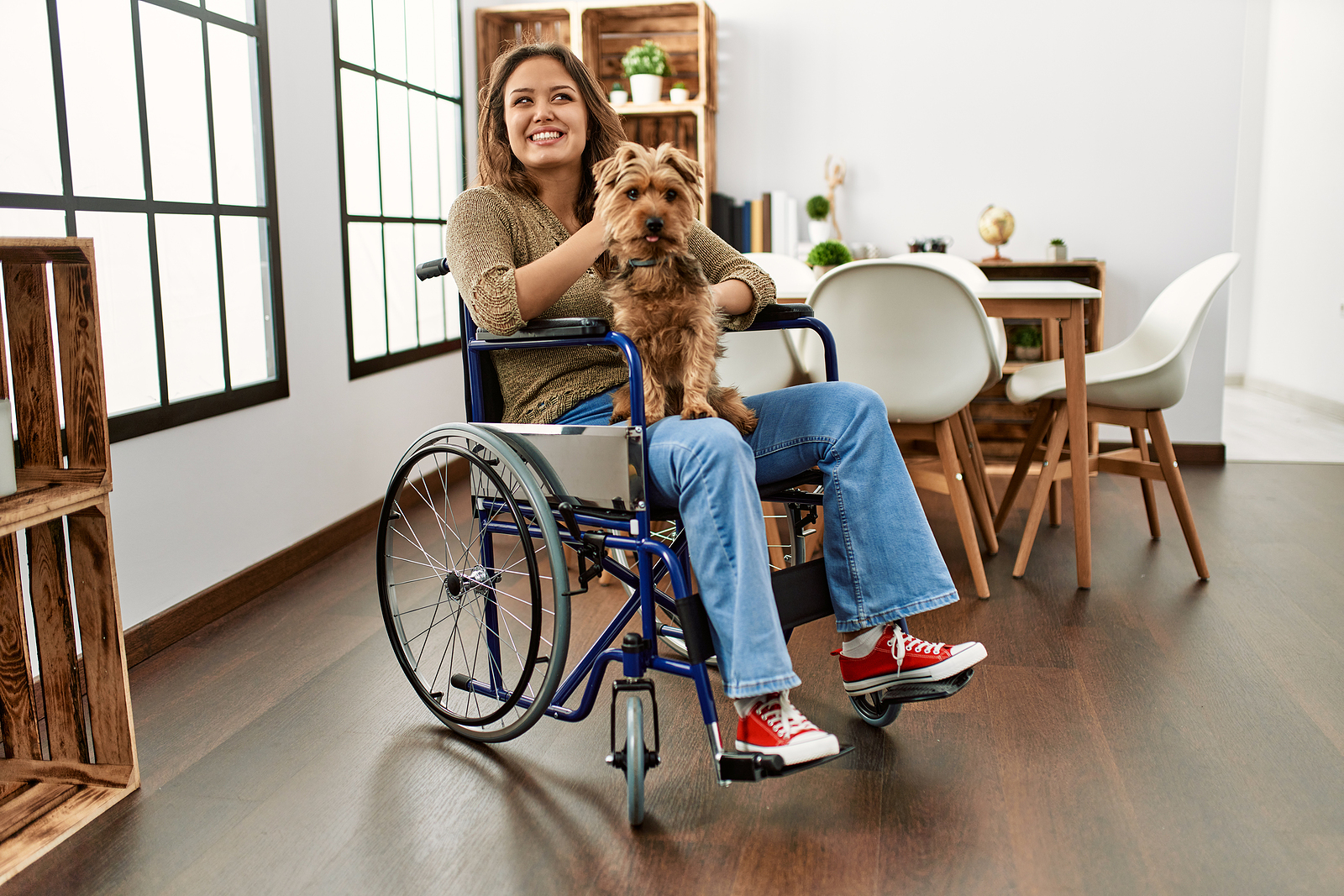 Hispanic woman in wheelchair holding cute dog in home made accessible by SMART home appliances Wilcox DC